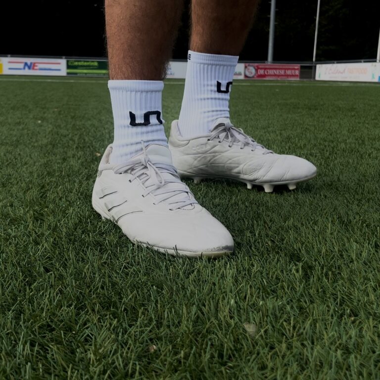 Witte voetbalschoenen op kunstgras met gripsokken